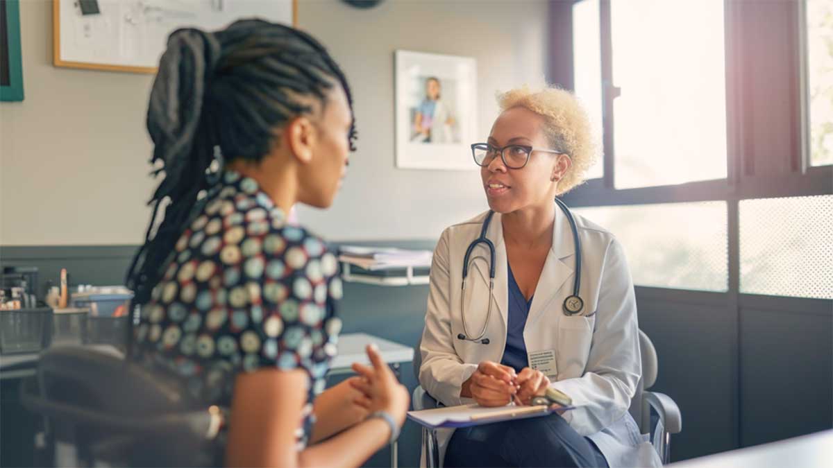 a woman consulting with her ob-gyn about when it's okay to get a pap smear test while on her period