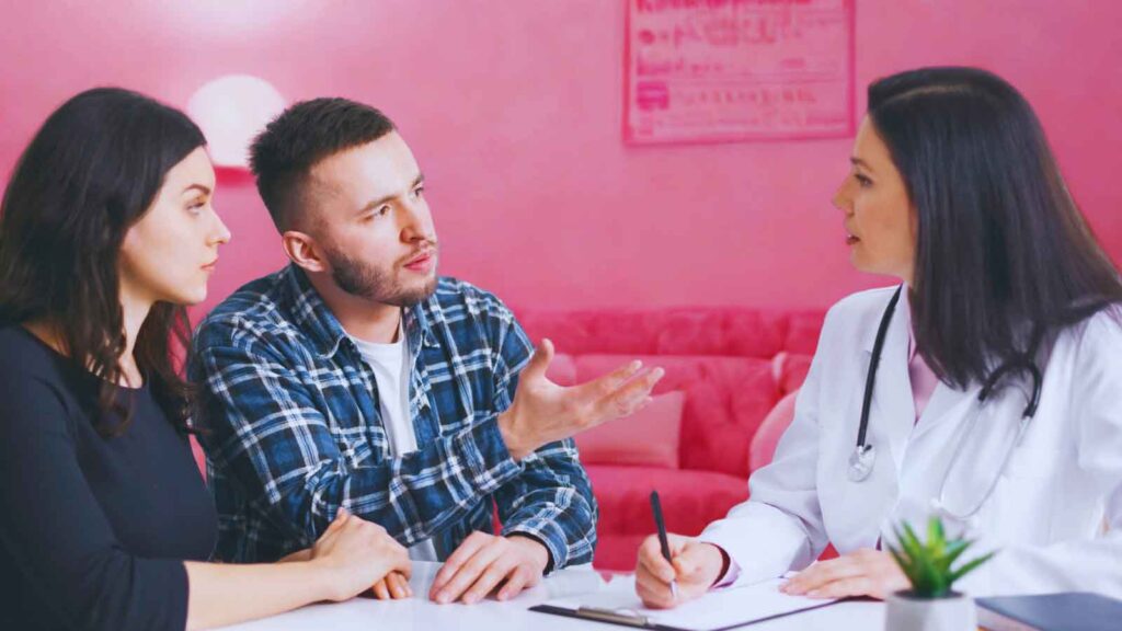 A couple discusses birth control myths with their OBGYN during a clinical consultation 