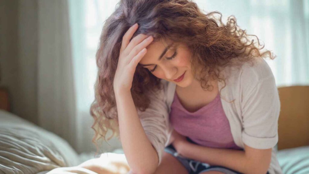Young woman experiencing fatigue and abdominal pain because her period bleeds heavy.